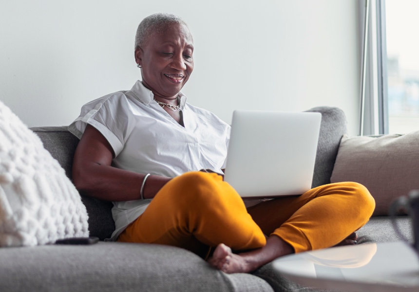 A woman sitting on the sofa working on her laptop. 